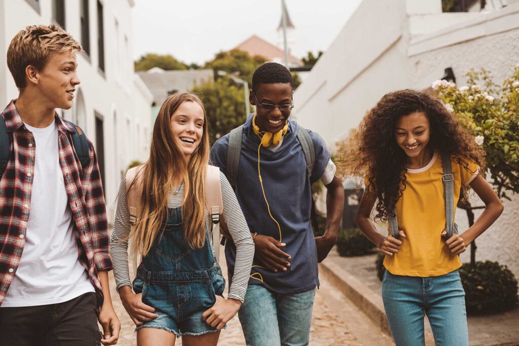 group of teens walking outside and smiling